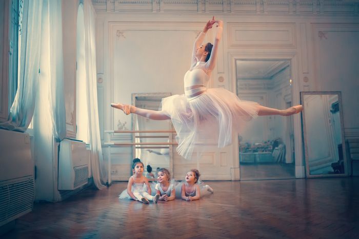 The frozen flight of an adult ballerina under the gaze of these little girls